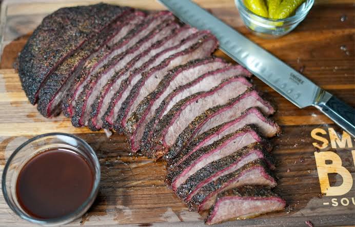 Brisket flat sliced to order on a cutting board